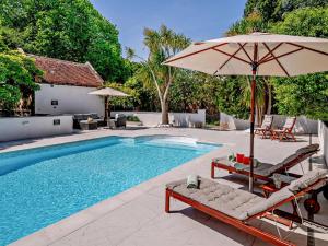 a swimming pool with two chairs and an umbrella at 1 Bed in Minehead oc-90923 in Minehead