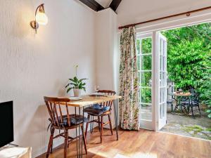 a dining room with a table and chairs and a sliding glass door at 1 Bed in Minehead oc-90923 in Minehead
