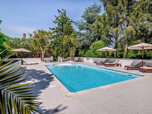 a swimming pool with chairs and umbrellas in a yard at 1 Bed in Minehead oc-90923 in Minehead +22 photos