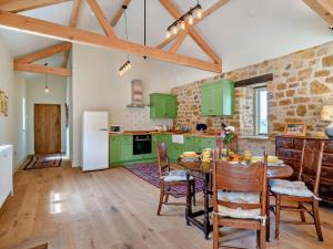 a kitchen with green cabinets and a table with chairs at 2 Bed in Stoke Abbott oc-94406 in Stoke Abbott +24 photos