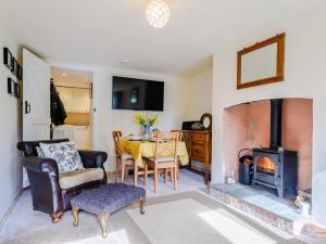 a living room with a table and a wood stove at 2 Bed in Crediton oc-79431 in Sandford