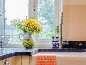 a vase filled with flowers sitting on a kitchen counter at 2 Bed in Crediton oc-79431 in Sandford +17 photos