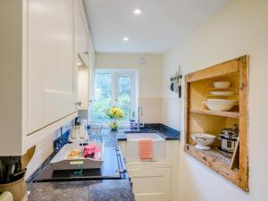 a kitchen with white cabinets and a blue counter top at 2 Bed in Crediton oc-79431 in Sandford