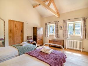 a bedroom with two beds and two windows at 2 Bed in Stoke Abbott oc-94406 in Stoke Abbott