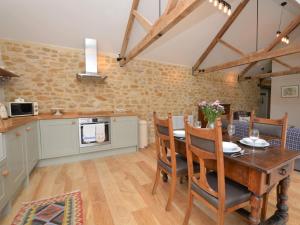 a kitchen and dining room with a wooden table and chairs at 2 Bed in Stoke Abbott oc-50884 in Stoke Abbott +21 photos