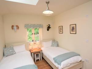 two twin beds in a room with a window at 2 Bed in Stoke Abbott oc-50884 in Stoke Abbott