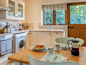 a kitchen with a table with a plate of food on it at 1 Bed in Tiverton oc-94766 in Bampton +13 photos