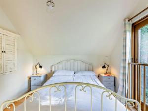 a bedroom with a white bed and two night stands at 1 Bed in Tiverton oc-94766 in Bampton
