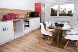 a kitchen with a table and white cabinets at Forest Monteurzimmer & Fewo für Firmen & Gruppen in Bad Bevensen