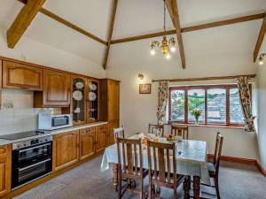 a kitchen with a table and a dining room at 3 Bed in Holsworthy oc-tcsheph in Merryfield