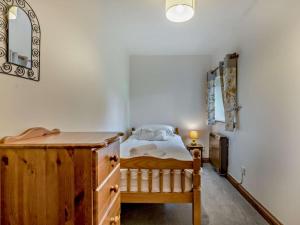 a bedroom with a bed and a dresser and a mirror at 3 Bed in Holsworthy oc-tcsheph in Merryfield