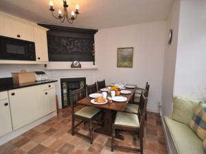a kitchen with a wooden table with chairs and a dining room at 3 Bed in Exeter oc-harri in Talaton