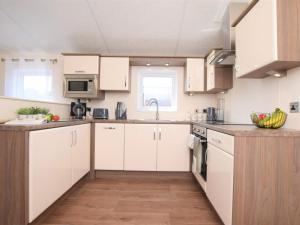 a kitchen with white cabinets and a sink at 2 Bed in Honiton oc-76515 in Ottery Saint Mary +8 photos