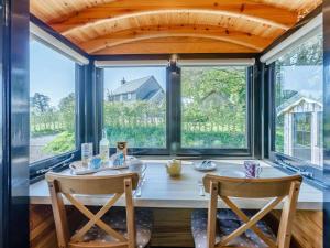a dining room with a table and chairs and windows at 1 Bed in Exeter oc-75423 in Longdown