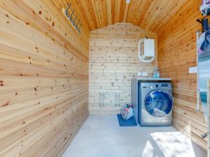 a washer and dryer in a wood paneled laundry room at 1 Bed in Exeter oc-75423 in Longdown