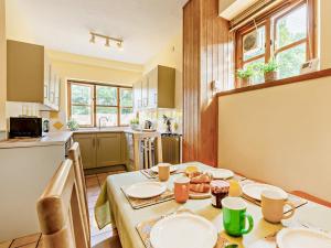 a kitchen with a table with plates on it at 3 Bed in Taunton oc-96235 in West Quantoxhead +23 photos