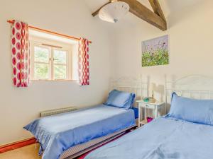a bedroom with two beds and a window at 3 Bed in Taunton oc-96235 in West Quantoxhead