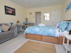 a bedroom with a bed and a couch at 1 Bed in Bridport oc-41890 in Charmouth