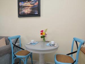 a white table with two chairs and a table with flowers at 1 Bed in Bridport oc-41890 in Charmouth +9 photos
