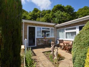 a house with a patio with a table and chairs at 1 Bed in Bridport oc-41890 in Charmouth