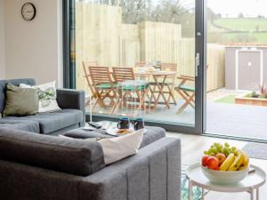 a living room with a couch and a table with a bowl of fruit at 3 Bed in Holsworthy oc-90721 in Holsworthy +22 photos