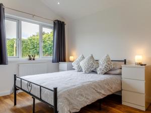 a bedroom with a large bed with two windows at 2 Bed in Brixham oc-78565 in Brixham +12 photos