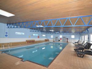 a large swimming pool in a building with chairs at 2 Bed in Brixham oc-78565 in Brixham