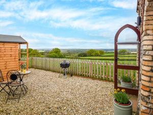 a patio with a grill and a fence at 1 Bed in Okehampton oc-78799 in Hatherleigh