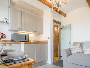 a kitchen with white cabinets and a couch in a room at 1 Bed in Okehampton oc-78799 in Hatherleigh