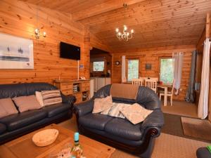 a living room with a leather couch in a cabin at 2 Bed in Tiverton oc-wonha in Bampton