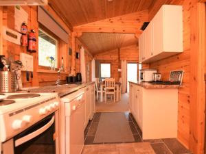a kitchen in a log cabin with a stove at 2 Bed in Tiverton oc-wonha in Bampton