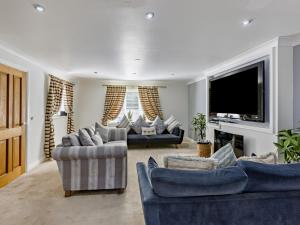 a living room with couches and a flat screen tv at 4 Bed in Bideford oc-nilga in Bideford