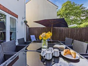 a table with croissants and a vase of flowers and an umbrella at 4 Bed in Bideford oc-nilga in Bideford