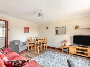 a living room with a couch and a tv and a table at 2 Bed in Taunton oc-41906 in Cothelstone