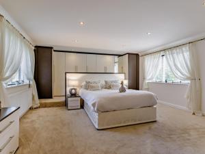 a bedroom with a large bed and two windows at 4 Bed in Bideford oc-nilga in Bideford