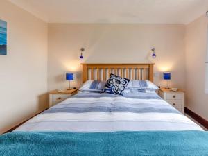 a bedroom with a large bed with blue and white stripes at 2 Bed in Taunton oc-41906 in Cothelstone