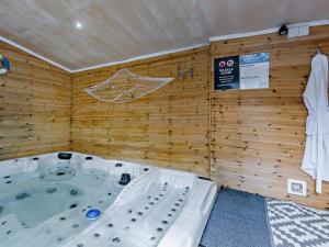 a jacuzzi tub in a room with wooden walls at 4 Bed in Bideford oc-nilga in Bideford +30 photos