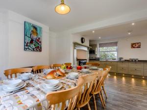 a dining room with a long table with wooden chairs at 5 Bed in Holsworthy oc-79454 in Milton Damerel