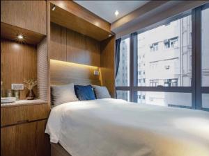 a bedroom with a large bed and a large window at Oootopia West in Hong Kong +2 photos