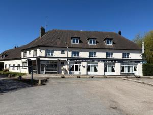 a large white building with a black roof at Hôtel L'escale des Hayons in Esclavelles