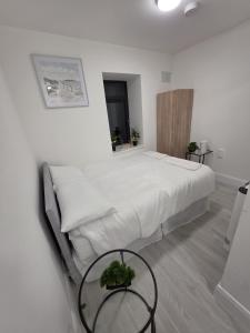 a white bedroom with a bed and a table at Milk Market Inn in Limerick