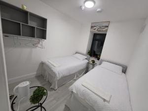 a white room with two beds and a window at Milk Market Inn in Limerick +14 photos