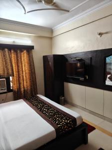 a bedroom with a bed and a tv on the wall at Hotel jewel in Haridwār