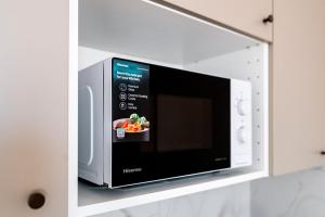 a microwave oven with a bowl of food in it at Super Central Modern Flat with Balcony & View! #55''Smart TV #Fast Wi-Fi #Metro in Warsaw