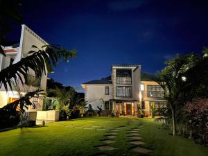 a house with a green lawn at night at Silva Montana in Mount Kenya