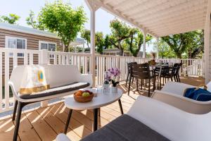 a patio with white furniture and a table and chairs at Club del Sole Adriatico Cervia Easy Camping Village in Cervia