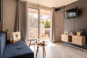 a living room with a couch and a tv at Club del Sole Adriatico Cervia Easy Camping Village in Cervia