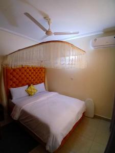 a bedroom with a large bed with an orange headboard at Rose homes in Mombasa