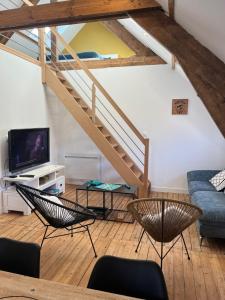 a living room with a staircase and chairs at L'Universel, 3 ch calme et cosy près de la plage in Wimereux