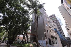 a building with a palm tree in front of it at Hotel Pune Pride, Baner in Pune